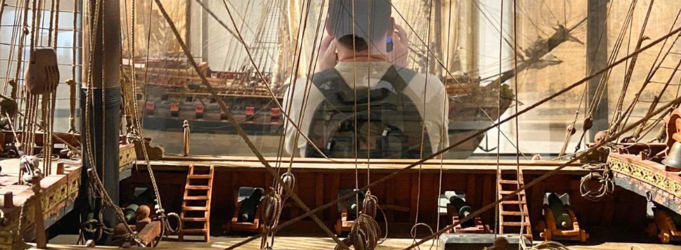 A tourist takes a picture of a model of a ship inside the Museum of Palazzo Poggi