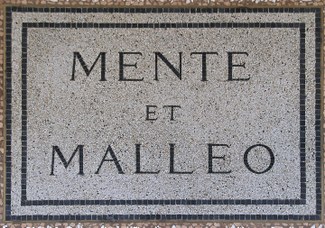 Geologists' universal motto "Mente et malleo" (mind and hammer), coined by Giovanni Capellini. Commemorative plaque (1881)