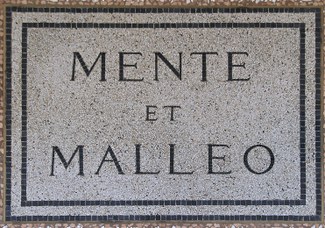 Motto universale dei geologi "Mente et malleo", coniato da Giovanni Capellini. Lapide posta nel 1881