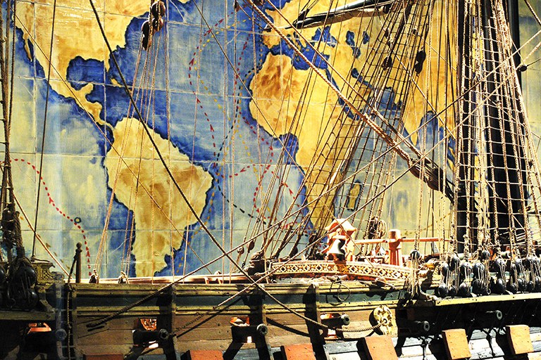 Modello di vascello con alle spalle una cartina geografica Modello di vascello con alle spalle una cartina geografica